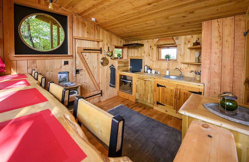 A well-equipped kitchen and dining space in Coucoo La Réserve's cabins